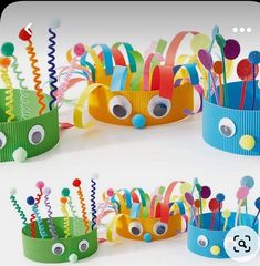 several colorful paper crowns with eyes and hair clips