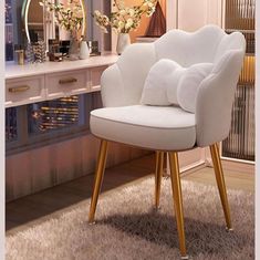 a white chair sitting on top of a rug in front of a desk with a mirror