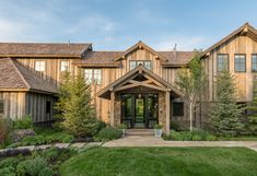 a large wooden house sitting on top of a lush green field