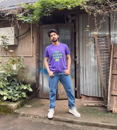 a man standing in front of a house with his hands on his hips and looking at the camera