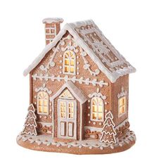 a small gingerbread house with lit windows and snow on the roof is shown in front of a white background