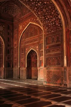 an intricately designed building with red and gold walls, arches and doorways in the middle