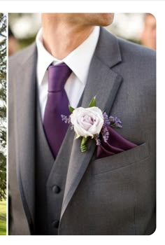 a man wearing a suit and tie with a flower in his lapel pin on his lapel