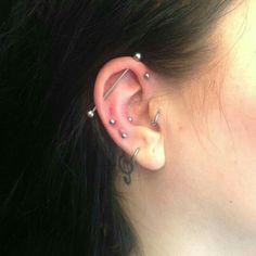 a woman's ear has three piercings on it