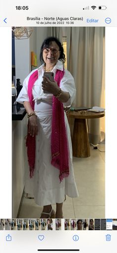 a woman taking a selfie with her cell phone while wearing a white dress and pink scarf