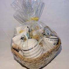 a basket filled with white dishes sitting on top of a table