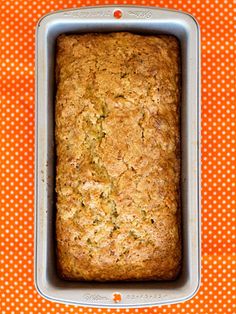 a loaf of bread in a pan on an orange tablecloth