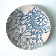 a blue and white lace doily on a white surface