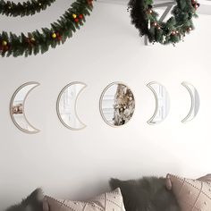 a living room with white walls decorated for christmas and moon phases hanging on the wall