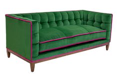 a green couch with pink piping on the armrests and back rests against a white background