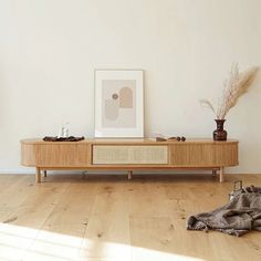 a living room with wood flooring and a wooden tv stand on top of a hard wood floor