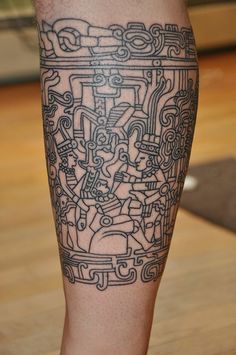 a man's leg with an egyptian tattoo on it