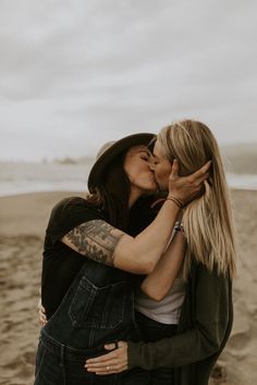 two women kissing each other on the beach