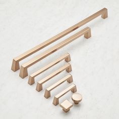 an assortment of wooden handles and knobs on a white surface