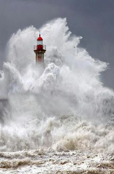 a lighthouse in the middle of a large wave with it's light house on top