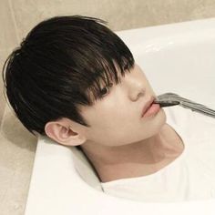 a young man is brushing his teeth in the bathtub with a fork and knife