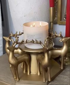 a candle is sitting on top of a stand with deer candlesticks in front of it