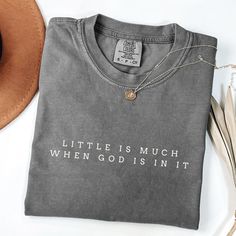 Shop for other awesome stuff: https://athreadoffaithco.etsy.com Little is Much T-Shirt Celebrate the power of faith with our Comfort Colors t-shirt featuring the simple yet profound message: "Little is Much When God is in It." Designed in a minimalistic font for a clean and timeless look. Details: Material: 100% ring-spun cotton Feel: Soft-washed, garment-dyed for extra coziness Fit: Relaxed, unisex sizing (size up for an oversized fit) Design: Minimalistic font with a powerful faith message Shi Cute Christian Tshirts, Christian Shirts For Men, Christian Tshirt Design Ideas, Bible Verse Shirts, Bible Verse Inspirational, Bible Verse Tees, Bible Shirts