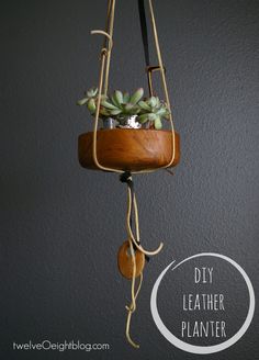 a hanging planter with succulents in it and the words diy leather planter below