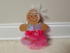 a ginger doll is sitting on the floor with pink tulle skirt and snowflakes in her hair