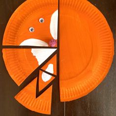 an orange paper plate that has been cut out to look like a face on it