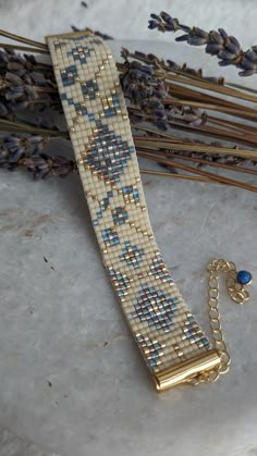 a beaded bracelet sitting on top of a table next to some dried lavenders