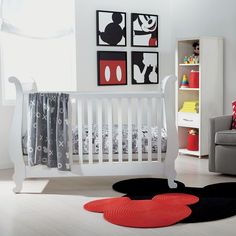 a baby's room with mickey mouse rugs and pictures on the wall above it