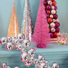 christmas decorations on a mantel with pink and silver ornaments