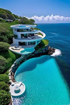 an aerial view of a modern house on the water's edge with swimming pool