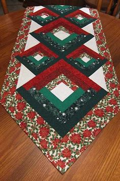 a quilted table runner sitting on top of a wooden table