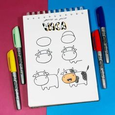 a notepad with three cartoon cows on it next to two markers and one pen