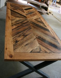 a table made out of wood with metal legs and an arrow design on the top