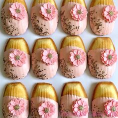 twelve decorated cakes with pink frosting and flowers on them, arranged in the shape of bundts