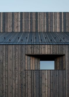 the side of a wooden building with an open window