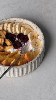 a bowl filled with fruit and yogurt on top of a table