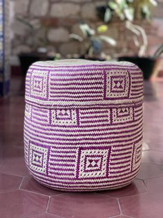 a purple and white ottoman sitting on top of a tile floor