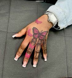 a woman's hand with pink butterflies on it