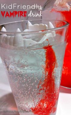 a glass filled with liquid and ice next to a jar