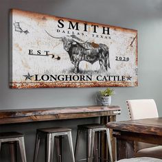 an old metal sign hangs on the wall above a wooden table and bar stools