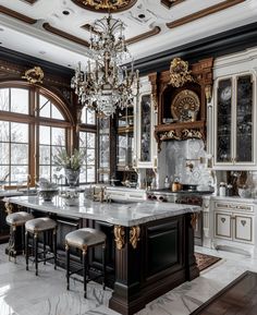 a large kitchen with marble counter tops and gold trimmings on the ceiling, along with an ornate chandelier