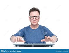 a man in glasses sitting at a desk with his hands open and pointing to the screen