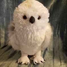 a white stuffed owl sitting on top of a chair