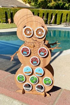 a wooden sculpture made to look like a snowman with donuts in his mouth