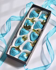 a box filled with blue and white chocolates on top of a blue satin ribbon