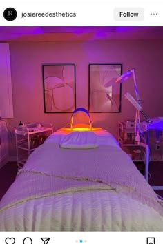 an image of a bed that is lit up with purple lighting and some pictures on the wall