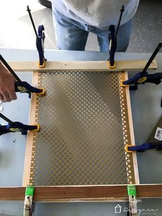 a man is working on a piece of wood with pliers and screwdrives