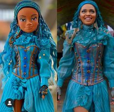 the doll is wearing a blue dress and headpiece