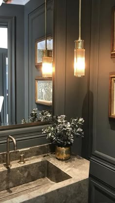 a bathroom sink sitting under a large mirror next to a wall mounted faucet