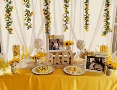 a baby shower table with sunflowers and pictures