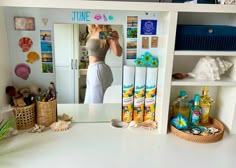 a woman taking a selfie in front of a mirror with various items on the counter